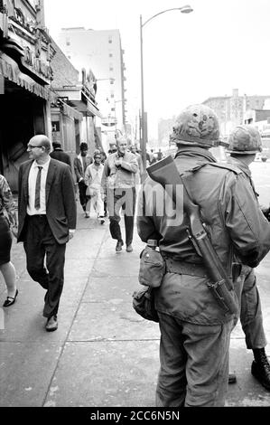 Des membres de la Garde nationale patrouillent dans les rues alors que des piétons se prominaient après les émeutes qui ont suivi l'assassinat du Dr Martin Luther King Jr, Washington, D.C., États-Unis, Warren K. Leffler, 8 avril 1968 Banque D'Images