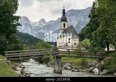 Église Saint-Sébastien avec ruisseau de montagne et pont à Ramsau, Berchtesgaden, Allemagne. Banque D'Images