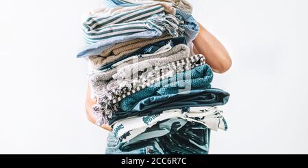 Femme prend dans les mains grande pile bleu et beige linge Banque D'Images