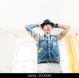 Danseuse d'art moderne tattooed vêtue d'un Jean gilet et noir chapeau posant le portrait Banque D'Images