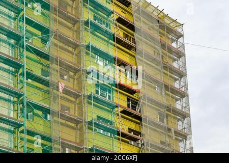 échafaudage et filet de sécurité autour de la maison pour installer thermique isolation de la façade du bâtiment d'appartement Banque D'Images