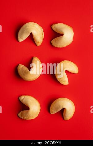 Petits gâteaux chinois chanceux. Cookies fortune sur fond rouge. Vue de dessus. Banque D'Images