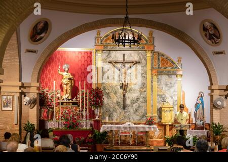 Huelva, Espagne - 15 août 2020 : autel principal du parrish San Bartolomé avec des fidèles en masse dans la ville de San Bartolomé de la Torre Banque D'Images