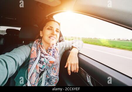 Femme aime la vue depuis la fenêtre de la voiture lorsqu'elle voyage en voiture Banque D'Images