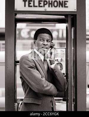 HOMME D'AFFAIRES AFRO-AMÉRICAIN ANXIEUX DES ANNÉES 1970 UNE EXPRESSION FACIALE INSTABLE DEBOUT DANS LA CABINE TÉLÉPHONIQUE URBAINE EN UTILISANT LE TÉLÉPHONE PAYANT - T6311 HAR001 HARS JEUNE ADULTE INFORMATION TECHNOLOGIE INQUIÉTUDE STYLE DE VIE MOODY COMMUNIQUER COPIE ESPACE DEMI-PERSONNES HOMMES EXPRESSIONS TROUBLES B&W CONCERNÉ TRISTESSE COSTUME ET LE STAND DE VENTE TIE UN SERVICE CLIENT ANXIEUX PAIE AFRO-AMÉRICAINS AFRO-AMÉRICAINS ETHNICITÉ NOIRE ET DANS LES PROFESSIONS DE L'HUMEUR TÉLÉPHONES UTILISANT LA CONNEXION CONCEPTUELLE GLUM TÉLÉPHONES ÉLÉGANT UNSTABLE MISÉRABLE VENDEURS HOMMES JEUNE ADULTE HOMME NOIR ET HAR001 BLANC À L'ANCIENNE AFRO-AMÉRICAINS Banque D'Images