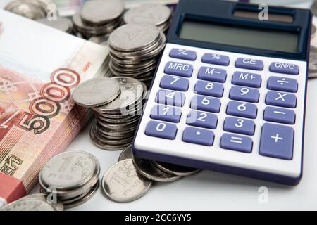 Un paquet de 5000 roubles billets et de nombreuses pièces russes et de la calculatrice Banque D'Images