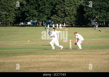 Une équipe de cricket amateur jouant sur un village vert, Lindfield, West Sussex, Angleterre, Royaume-Uni Banque D'Images