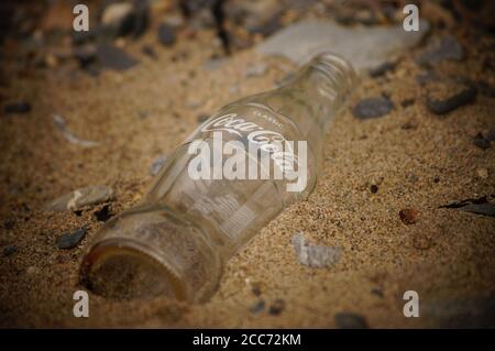 Bouteille de Coca-Cola dans le sable (bouteille en verre) Banque D'Images