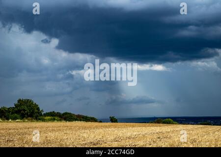 la pluie tombe dans les stries d'un nuage dans la zone de campagne, champ au premier plan, le temps Banque D'Images