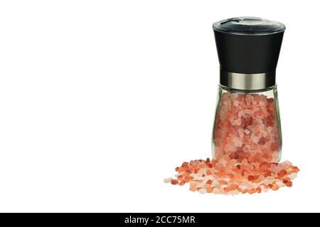 Cristaux de sel de l'Himalaya rose dans un moulin à verre. Sel rose de l'Himalaya dans un moulin isolé sur fond blanc. Banque D'Images