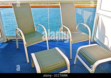Chaises longues vides sur un balcon de stateroom de bateau de croisière Banque D'Images