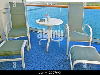 Chaises longues vides sur un balcon de stateroom de bateau de croisière Banque D'Images