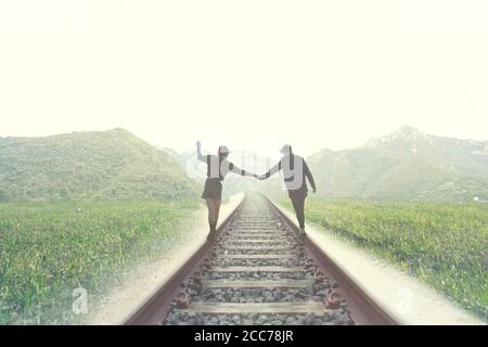 un jeune couple marche sur les rails jusqu'à une destination inconnue Banque D'Images