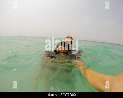 Prenant un selfie dans les Caraïbes, un couple bob leur tête au-dessus de l'eau Banque D'Images