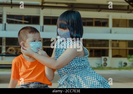 Deux enfants portent de la masse pour se protéger contre le coronavirus. Banque D'Images