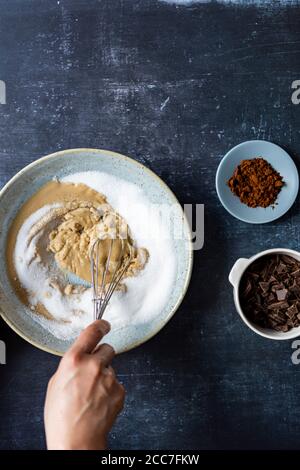 Chuchoter le sucre avec du tahini dans un bol en céramique sur fond sombre, des morceaux de chocolat et du café turc accompagnent. Banque D'Images