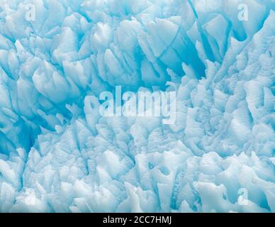 Vue rapprochée d'un iceberg, avec une gamme de teintes bleues et de formes et de motifs intéressants, flottant le long de la côte de l'Antarctique. Banque D'Images