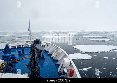 Un navire de croisière Quark Expeditions navigue à travers la glace de la peloton d'épaississement le long de la péninsule antarctique en direction du sud vers le cercle antarctique. Banque D'Images