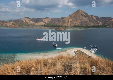 Des bateaux de la sorte utilisé pour emmener les touristes de Labuan Bajo au parc national de Komodo en Indonésie, amarrer à une plage de sable parmi les îles des parcs. Banque D'Images