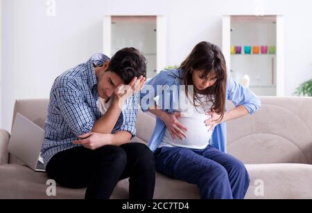 La femme enceinte avec son mari à la maison Banque D'Images