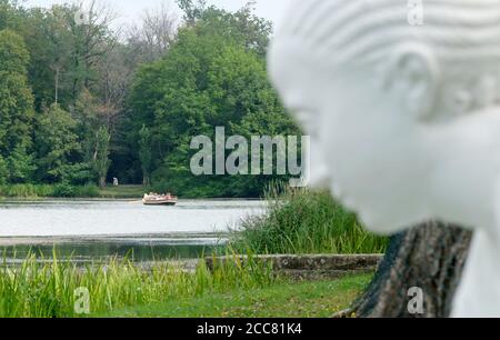 18 août 2020, Saxe-Anhalt, Wörlitz : les visiteurs du Wörlitz Garden Kingdom se rendent sur une gondole au-dessus d'un étang. Au premier plan se trouve une statue. Il y a 20 ans, les parcs près de Dessau ont été reconnus comme patrimoine culturel mondial. Photo: Sebastian Willnow/dpa-Zentralbild/dpa Banque D'Images