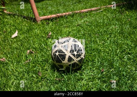 Ballon de football en cuir noir et blanc près du poteau de but. Banque D'Images