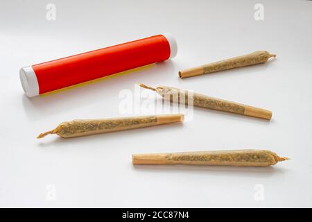 Un emballage en plastique blanc et rouge de cannabis pour les Prerolls Ou des articulations avec pré-rouleaux de cannabis joints autour et un sur un arrière-plan blanc Banque D'Images