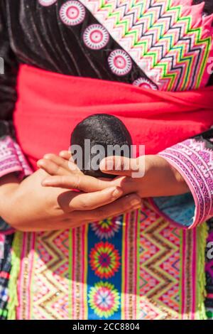 Gros plan sur les mains de la jeune fille tribale de Hmong tenant une corde de coton tissée tout en jouant à un match de jet de balle dans la célébration du nouvel an de Hmong en Thaïlande. Banque D'Images