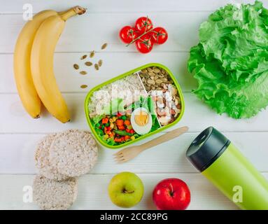 Boîte à lunch remplie de riz et de légumes et de noix mélangés près de thermos mug Banque D'Images