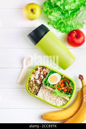 Boîte à lunch remplie de riz et de légumes mélangés sur blanc arrière-plan en bois Banque D'Images