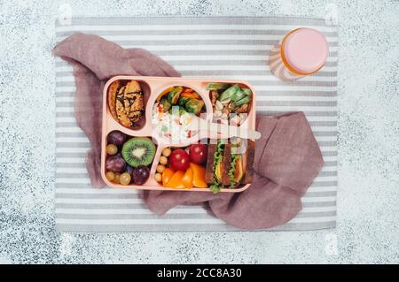 Panier repas avec sandwichs, salade de légumes, fruits frais, riz et noix Banque D'Images