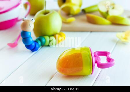 Grignoteuse avec morceaux de pomme près des fruits et de la chenille jouet Banque D'Images