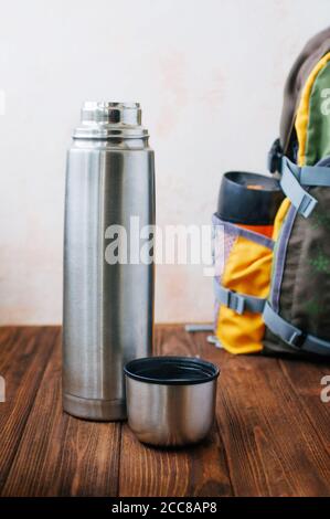 Ouvrir la bouteille de thermos avec de l'eau bouillante sur fond de bois Banque D'Images