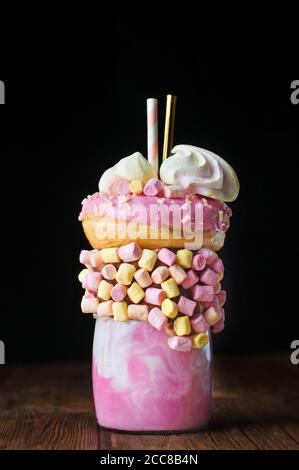 Shake au freak aux framboises sur une table en bois rustique sur fond noir Banque D'Images