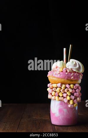 Shake au freak aux framboises sur une table en bois rustique sur fond noir Banque D'Images