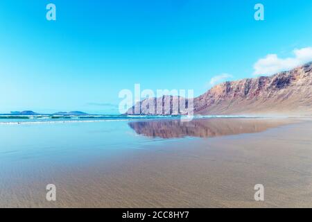Panorama de la belle plage et de la mer tropicale de Lanzarote. Canaries. Côte de la plage de Famara, île de Lanzarote, îles Canaries. Touristes sur le plus pop Banque D'Images