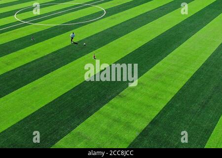 (200820) -- GOLOG, 20 août 2020 (Xinhua) -- photo aérienne prise le 19 août 2020 montre un villageois jouant au football dans un stade près du village de Ghadan dans le canton de Machali, comté de Madoi, préfecture autonome tibétaine de Golog, province Qinghai du nord-ouest de la Chine. En octobre 2018, un total de 1,036 000 résidents recensés, victimes de la pauvreté, ont déménagé des terres moins hospitalières du comté de Madoi à Ghadan, un village de réinstallation récemment construit dans la région source de la rivière Yellow. Le nouveau village dispose d'un meilleur transport, ce qui permet aux villageois de trouver plus facilement des emplois ou de démarrer des entreprises dans d'autres villes. Meanwh Banque D'Images