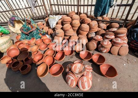 Orcha, Madhya Pradesh, Inde - Mars 2019: Une femme indienne assise dans un magasin de bord de route vendant des pots et ustensiles en terre cuite dans les rues de t Banque D'Images