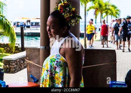 Moreea, Polynésie française: 09/03/2018: Portrait d'une femme locale habillant une robe typique avec des fleurs et des couleurs. Banque D'Images