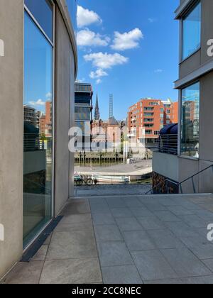 Vue intéressante à travers quelques maisons avec des réflexions dans la fenêtre du quartier du port (HafenCity) à Hambourg, Allemagne Banque D'Images