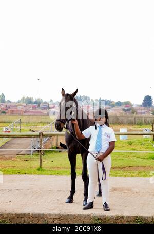 Soweto, Afrique du Sud - 16 avril 2012: Jeune garçon africain tenant les rênes d'un cheval Banque D'Images