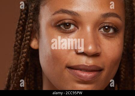 Gros plan du visage de la jeune femme africaine à la peau parfaite regarder l'appareil photo Banque D'Images