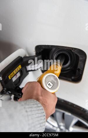 Gros plan de la main d'un homme remplissant le réservoir de sa voiture de diesel. Injecteur diesel B7 jaune Banque D'Images
