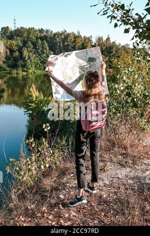 Photo en plein air d'un jeune routard élancé inspiré par le voyage, le repos actif, la tenue de la carte, le trajet suivant, bon pour orienter Banque D'Images