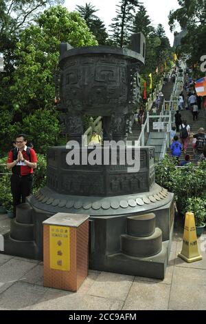 Boîte de donation et urne massive en laiton, au pied des 268 marches de la statue du Bouddha Tian (Grand Bouddha), Ngong Ping, île Lantau, Hong Kong, Chine Banque D'Images