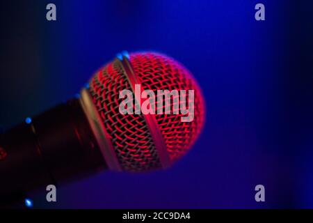 Microphone gros plan et macro, musique et voix parler instrument sur fond bleu. Voyant rouge. Banque D'Images