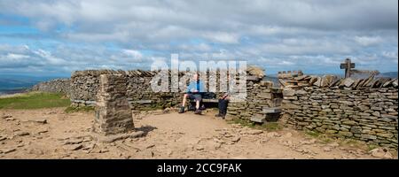 Deux randonneurs assis pour admirer la vue depuis le refuge de Pen-y-Ghent, l'un des trois sommets du Yorkshire Banque D'Images