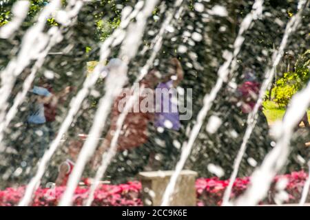 Danseuses du parc Fuxing vues à travers l'eau d'une fontaine à Shanghai. Banque D'Images