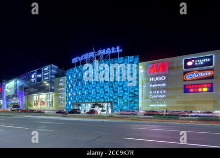Kiev, Ukraine - 08 août 2020: Centre commercial sur le remblai du fleuve Dniepr. La photo a été prise tard dans la soirée sur fond de lanternes lumineuses et d'un ciel sombre. Éditorial. Banque D'Images