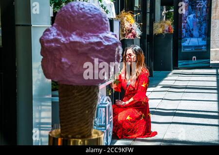 Une jeune femme posant avec quelques fleurs encadrées par un cône de glace dans le quartier branché de Xintiandi à Shanghai. Banque D'Images